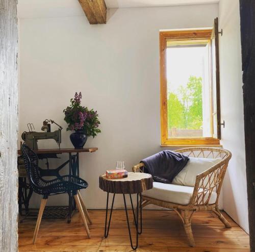 a room with a chair and a table and a window at Moje Podlasie - Dom w Siemichoczach in Siemiatycze