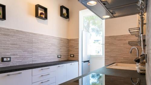 eine Küche mit weißen Schränken und einem Waschbecken in der Unterkunft Appartamento di Daniele in Portoferraio