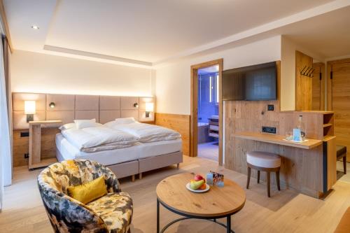Habitación de hotel con cama y mesa en Resort La Ginabelle, en Zermatt