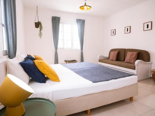 a bedroom with a large bed and a couch at Casa Blu Guesthouse - Casa de Hospedes in Santa Maria