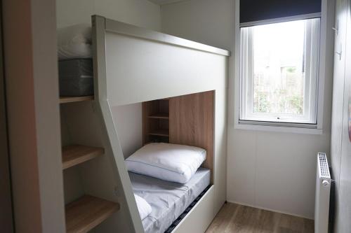 a bunk bed in a room with a window at 6 6-persoons Familie lodge in Voorthuizen