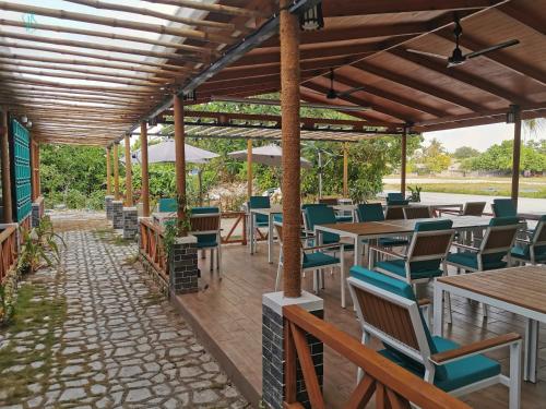 un patio en un restaurante con mesas y sillas en Village Hideaways & Spas en Fulhadhoo