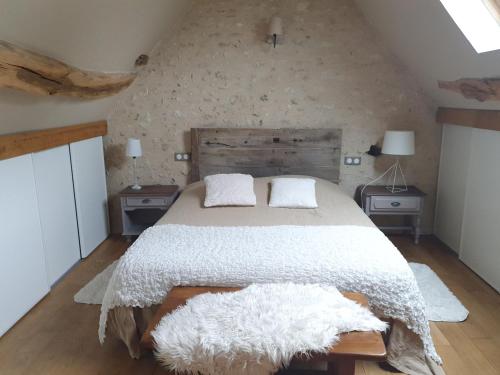 1 dormitorio con 1 cama con edredón blanco y 2 mesas en Gîte du "Chat botté" Zoo de Beauval Châteaux de La Loire 4 pers en Choussy
