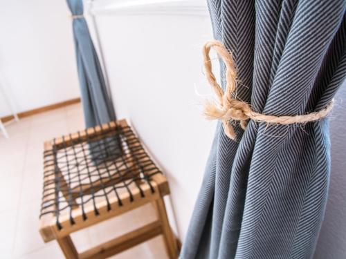 a room with a curtain and a wooden chair at Casa Blu Guesthouse - Casa de Hospedes in Santa Maria