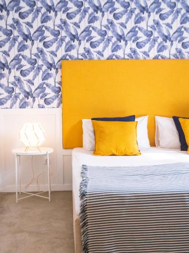 a bedroom with a bed with a yellow headboard at Casa Blu Guesthouse - Casa de Hospedes in Santa Maria