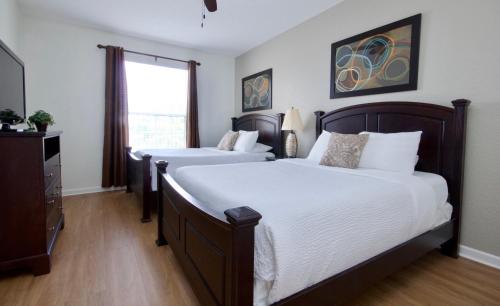 1 Schlafzimmer mit 2 Betten und einem Fenster in der Unterkunft Lake View Delight - Premium Condo Near Pool and Parks in Orlando