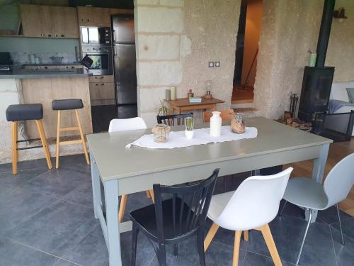- une table dans une cuisine avec des chaises blanches et un comptoir dans l'établissement Gîte du 