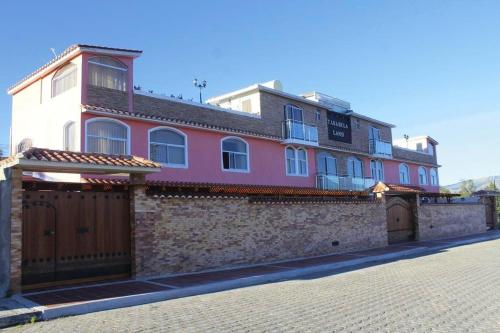 un edificio rojo y blanco en una pared de ladrillo en Hotel Tababela Land en Tababela