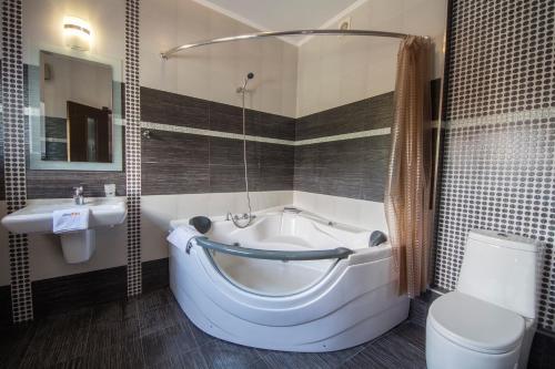 a bathroom with a tub and a toilet and a sink at DayFlat Apartments Maidan Area in Kyiv