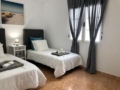 a bedroom with two beds and a window at Apartamento Playa Dorada Bajos in Playa Blanca