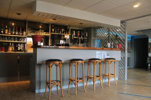 um bar com quatro bancos num balcão em Fasthotel Vendome em Vendôme