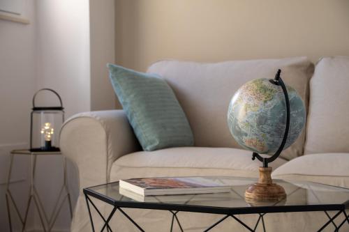 a globe on a glass table in front of a couch at Longo Suites in Taormina