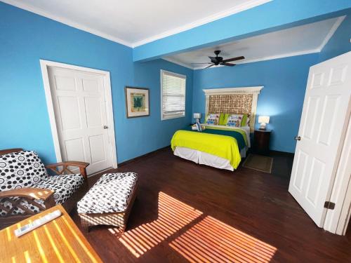 Un dormitorio con una cama amarilla y paredes azules en St John Inn, en Contant
