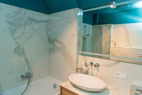 La salle de bains est pourvue d'un lavabo et d'une douche. dans l'établissement Apartmenthaus am Dom "Maisonette", à Zwickau
