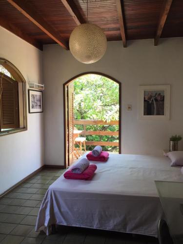 a bedroom with a large bed with red pillows on it at Enjoy Hostel e Pousada in Aracaju