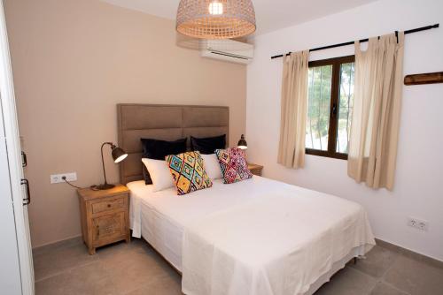 a bedroom with a white bed and a window at Casa Calma Moraira in Moraira