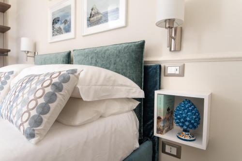 a bedroom with a bed with blue and white pillows at Longo Suites in Taormina