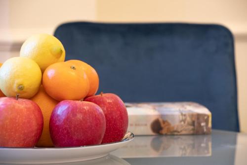 a bowl of apples oranges and lemons on a table at Longo Suites in Taormina