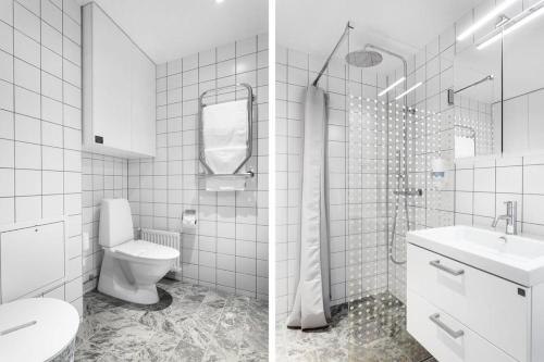 a white bathroom with a toilet and a sink at HOOM Home & Hotel Sollentuna in Sollentuna
