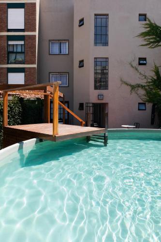 a swimming pool with a wooden bridge in a building at Hotel Alto San Isidro in San Isidro