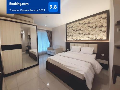 ein Schlafzimmer mit einem großen Bett in einem Hotelzimmer in der Unterkunft Apartemen Grand Kamala Lagoon Studio By Bonzela Property in Bekasi