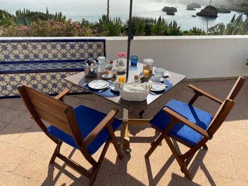 einen Tisch und zwei Stühle mit einer Mahlzeit auf dem Balkon in der Unterkunft Casa Três Palmeiras in Portimão