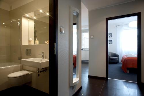 W łazience znajduje się umywalka, wanna i lustro. w obiekcie Apartamenty Starówka - Melody w Szczecinie