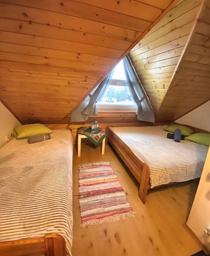 two beds in a room with a window at Karczma Kubalonka in Istebna