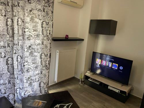 salon z telewizorem z płaskim ekranem i kanapą w obiekcie Jordans appartment w Salonikach