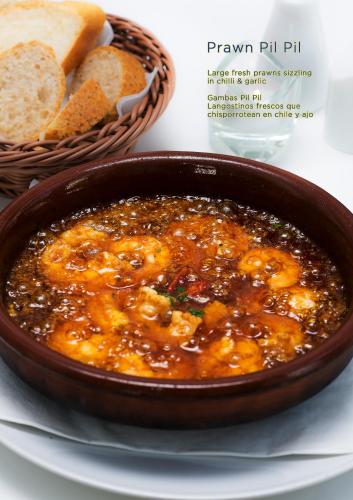 a bowl of stew with bread and a basket of bread at Hotel La Casa in Torrox