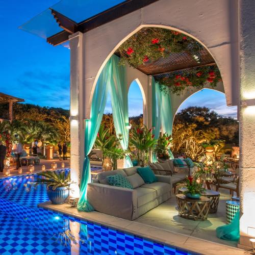 an outdoor living room with a couch and a pool at Pedra da Laguna Boutique Hotel SPA in Búzios