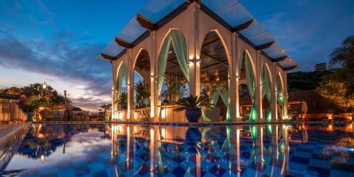 a building with a swimming pool at night at Pedra da Laguna Boutique Hotel SPA in Búzios