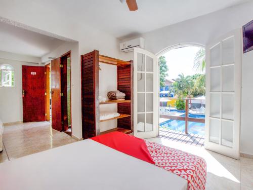 a bedroom with a bed and a view of a pool at OYO Pousada Recanto Shangrilá, Cabo Frio in Cabo Frio