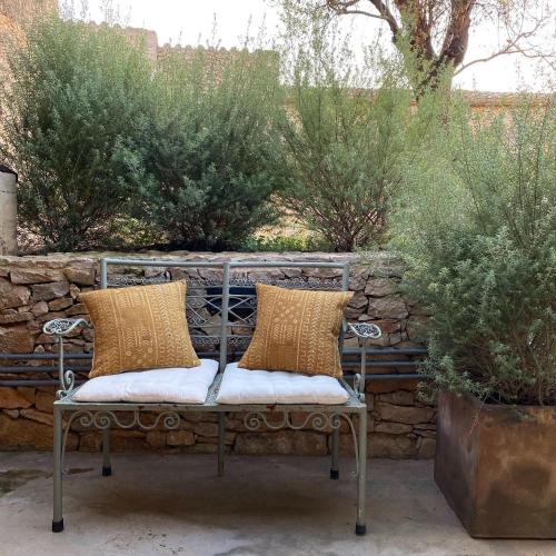 a bench with two pillows on it in a garden at Mas Ferran Adults Only in Pals