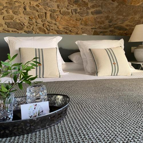 a bed with pillows and a tray with a plant on it at Mas Ferran Adults Only in Pals
