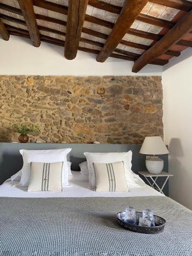a bedroom with a bed with a stone wall at Mas Ferran Adults Only in Pals