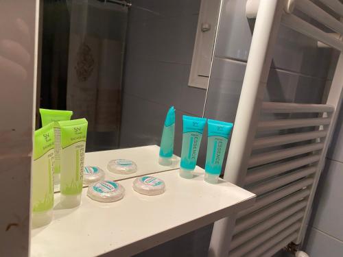 a counter with four bottles of toothbrushes and a mirror at Jordans appartment in Thessaloniki