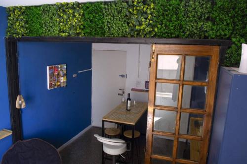 a room with a blue wall and a table and a door at Microstudio en Plaza San Martín in Mendoza