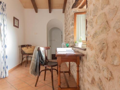 a dining room with a table and a stone wall at Ca'n Beneït in Binibona