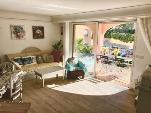 - un salon avec un canapé et une porte coulissante en verre dans l'établissement Résidence 4 etoiles Port Marine, à Sainte-Maxime