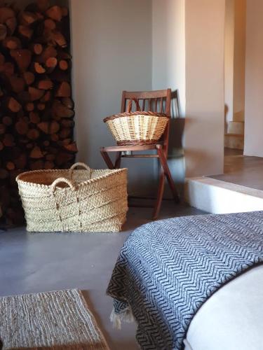 a bedroom with a bed and baskets and a chair at Mas Ferran Adults Only in Pals