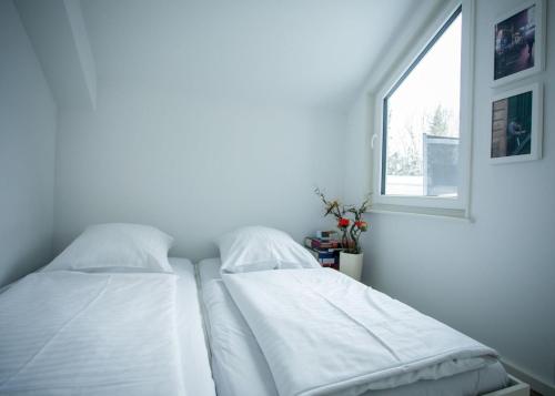 2 camas en una habitación blanca con ventana en Am Waltenberg 70-KO, en Winterberg