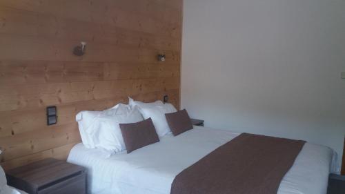 a bedroom with a white bed with a wooden headboard at Aiguille Noire in Valloire