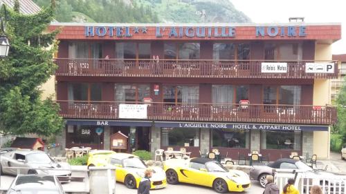 a hotel with cars parked in front of it at Aiguille Noire in Valloire