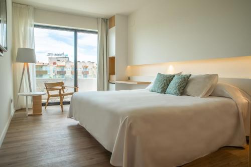 um quarto de hotel com uma cama e uma grande janela em Instants Boutique Hotel - Adults Only em Cambrils