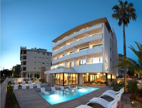 un edificio con piscina di fronte ad esso di Instants Boutique Hotel a Cambrils