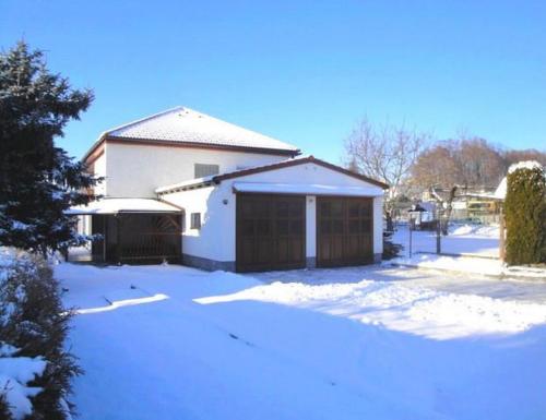 a house with a garage in the snow at Villa- Caba in Křemže