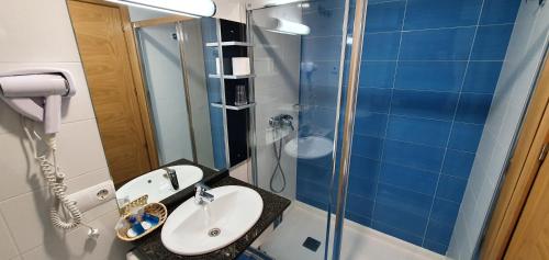 La salle de bains est pourvue d'un lavabo et d'une douche en verre. dans l'établissement Hotel Casa Ramon Molina Real, à Molinaseca