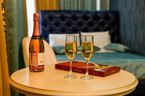 ヨシュカル・オラにあるHotel "Vernissage"の- シャンパン2杯、テーブルの上にボトル1本
