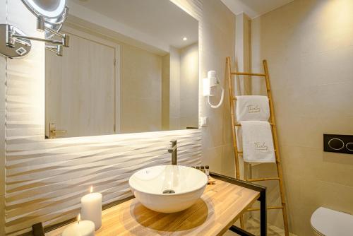 a bathroom with a sink and a mirror and candles at Thealos Santorini in Pirgos